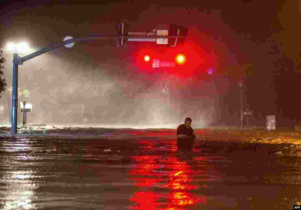 Lanny Dean, from Tulsa, Oklahoma, wades along a flooded Beach Boulevard next to Harrahs Casino as the eye of Hurricane Nate pushes ashore in Biloxi, Mississippi.