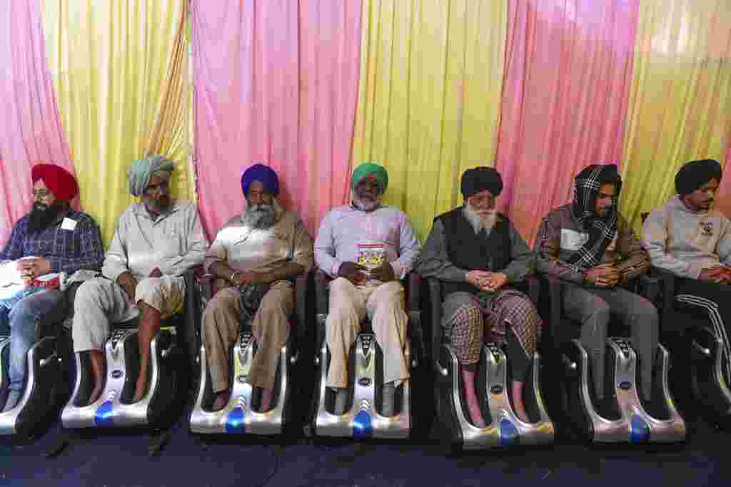Farmers get foot massage inside a tent as they continue to demonstrate against the central government's recent agricultural reforms, blocking a highway at the Delhi-Haryana state border in Singhu, India.