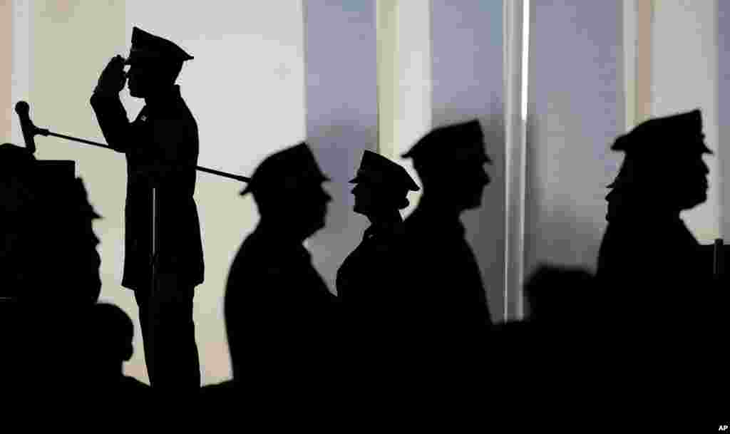 Jean Charlot, top, an officer with the Port Authority of New York and New Jersey Police Department, salutes as he is introduced on stage during a ceremony promoting him to his new rank as sergeant, at St. Peter's University in Jersey City, N.J.
