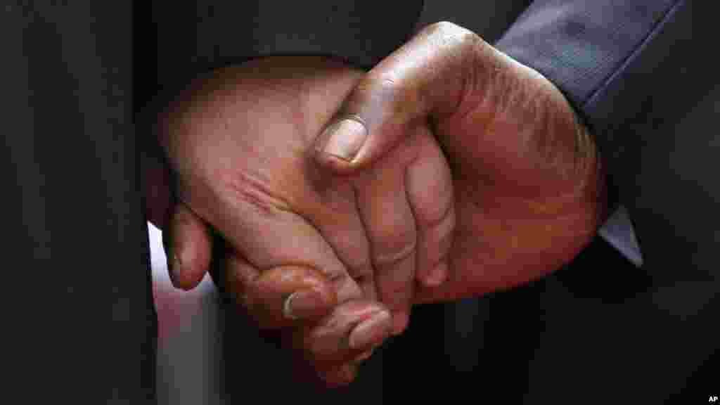 The hand of Chinese President Xi Jinping, left, holds the hand of Zimbabwean President Robert Mugabe, upon his arrival in Harare, Zimbabwe, Tuesday, Dec. 1. 2015. Jinping is in Zimbabwe for a two day State visit during which he is set to sign some bilateral agreements aimed at strengthening relationships between the two countries.