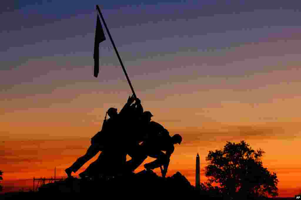 The rising sun turns the sky red and orange behind the U.S. Marine Corps War Memorial in Arlington, Virginia, just outside Washington D.C.