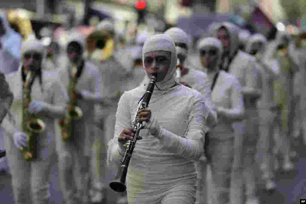 A marching band dressed as mummies plays during a parade of giant "alebrijes," fantastical creatures made from papier-mache and painted in bright colors, in Mexico City, Oct. 21, 2017.