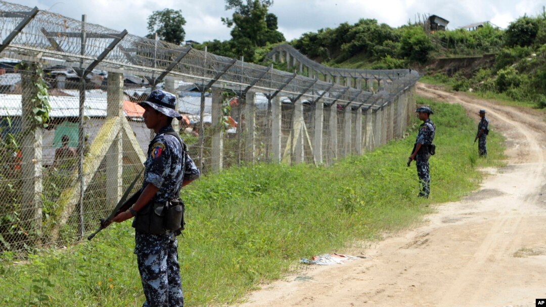 မွနျမာ-ဘငျ်ဂလားဒေ့ရျှ နှဈနိုငျငံနယျစပျအကွားရှိ "no man's land" ကိုကာရံထားသည့ျ ခွံစညျးရိုးနားတှငျ လုံခွုံရေးတာဝနျယူထားသည့ျ မွနျမာ နယျခွားစောင့ျ တပျဖှဲ့ဝငျမြား။ (တောငျပွိုလကျယာကြေးရှာအနီး၊ မောငျတောမွို့) (ဇှနျ ၂၉၊ ၂၀၁၈)