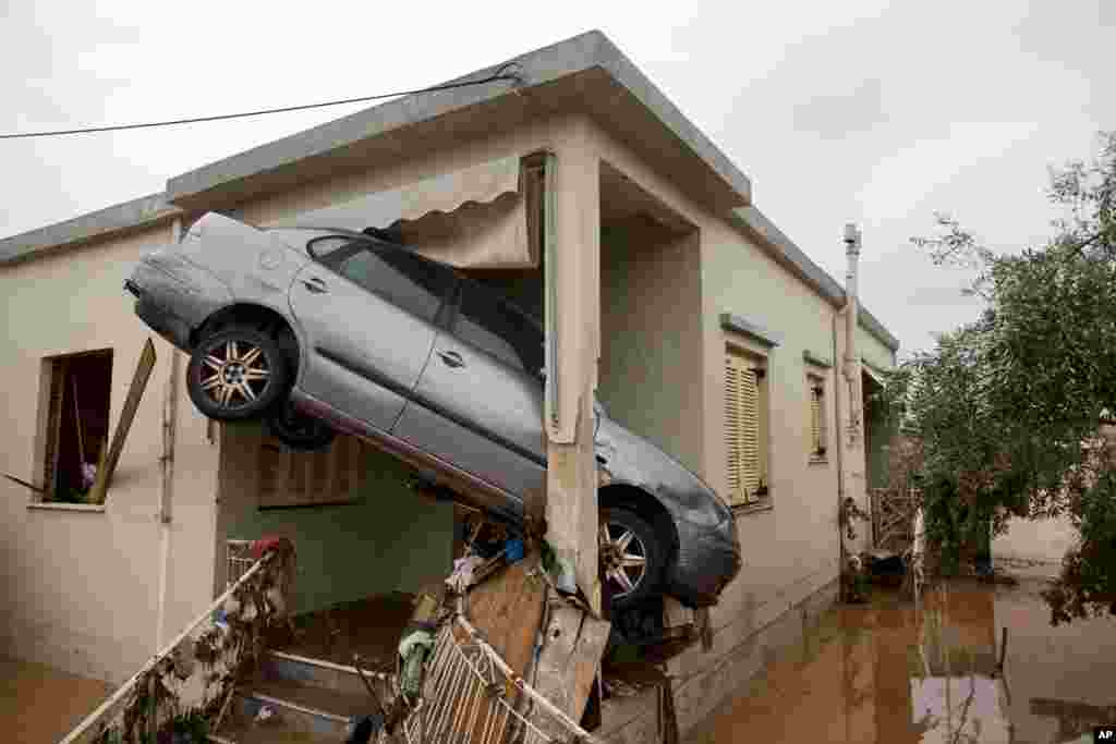A car is seen at the entrance of a flooded house after the water has receded in the town of Mandra western Athens, Greece.