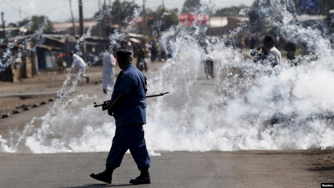 A policeman walks away after throwing a teargas canister during a protest against Burundi President Pierre Nkurunziza and his bid for a third term in Bujumbura, Burundi, June 2, 2015.