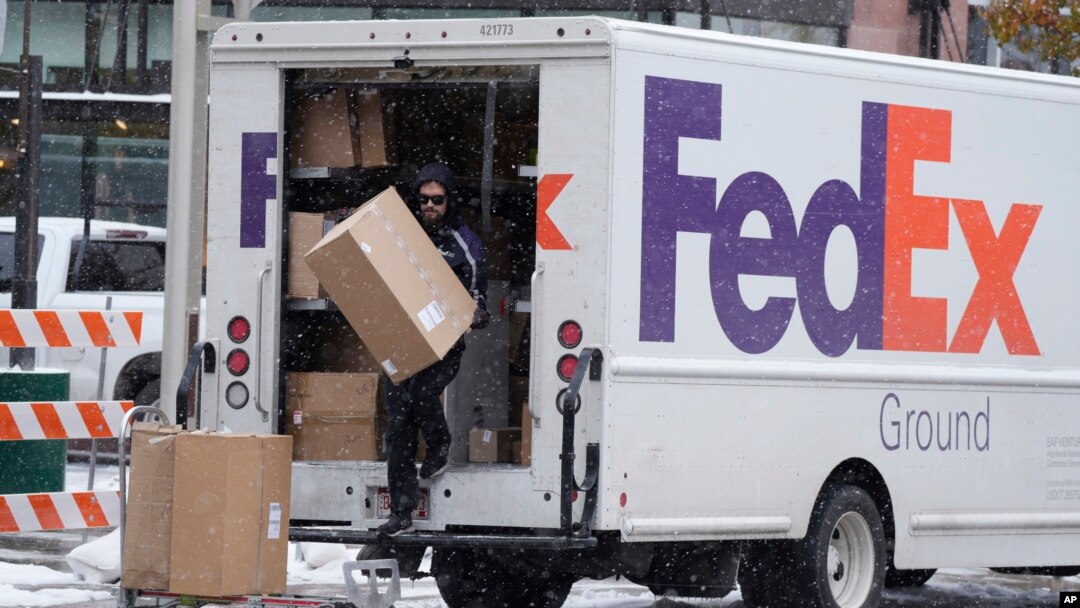 Foto Achiv: Yon anplwaye FedEx pote yon koli, 17 Nov. 2022. 