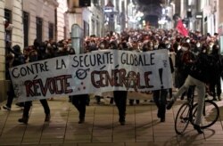 FILE - Masked protesters attend a demonstration as French parliament begins to discuss a proposed law that would make it a crime in some circumstances to circulate an image of a police officer's face, in Nantes, France, Nov. 17, 2020.
