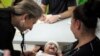A doctor examines a cleft-lipped baby during an evaluation provided by Operation Smile volunteers at San Felipe hospital in Tegucigalpa, November 14, 2012. 
