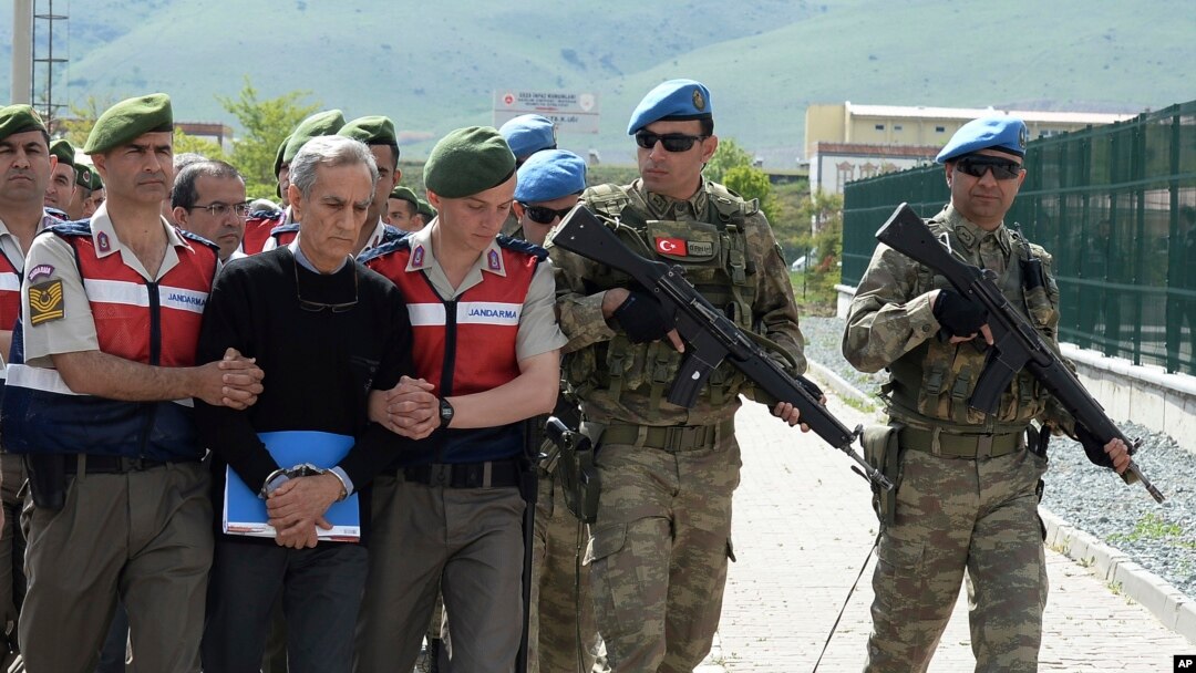 Paramilitary police officers and commandos escort alleged instigators of last summer's failed military coup, including former Air Force commander Gen. Akin Ozturk, front, before their trial at a courthouse near Ankara, Turkey, May 22, 2017.
