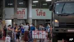 Migrant workers and their families get ready to be taken to a field hospital for COVID-19 patients in Samut Sakhon, South of Bangkok, Thailand on January 4, 2021. AP