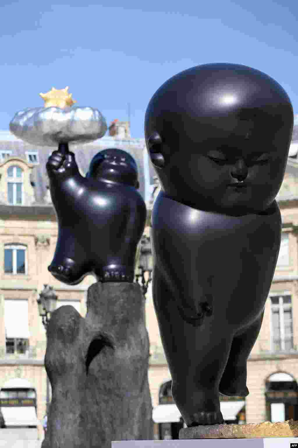 A picture taken at the place Vendome in Paris shows Taiwanese artist Li Chen's sculptures 'Floating Heavenly Palace' and 'Flickering Moonlight' (R).