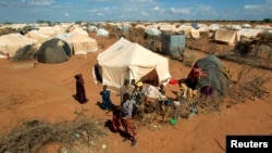 FILE - Refugees stand outside their tent at the Ifo Extension refugee camp in Dadaab, near the Kenya-Somalia border, Oct. 19, 2011. Ahmed Warsame, the new UNHCR director for global emergencies has led UNHCR operations in Dadaab.