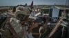FILE - A security personnel stands guard on top of a vehicle outside United Nations Assistance Mission in Afghanistan (UNAMA) office compound in Guzara district of Herat province, July 31, 2021.