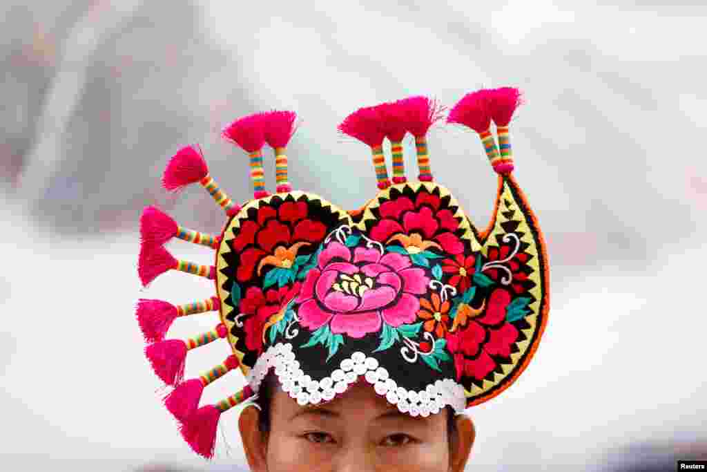 A woman wears traditional headgear during a session of the Yunnan province on the second day of the 19th National Congress of the Communist Party of China at the Great Hall of the People in Beijing.