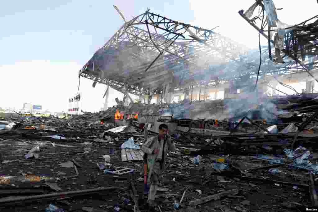 A Houthi fighter talks on the phone as he walks at the site of an airstrike on a parade square in Sana'a, Yemen, Nov. 5, 2017.