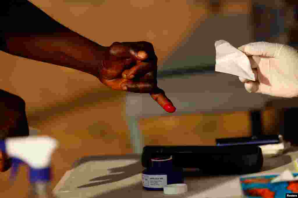 A person has a finger inked at a polling station during Ghana's presidential and parliamentary elections in Kyebi, Ghana.
