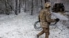 Seorang tentara Ukraina membawa satu unit Starlink di garis deopan pertempuran di Kreminna, Ukraina, pada 6 Januari 2023. (Foto: Reuters/Clodagh Kilcoyne)