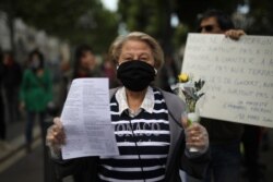 A protester holds the traditional lily of the valley flower during a banned May Day gathering in Marseille, southern France, May 1, 2020.