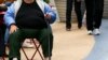 FILE - An overweight woman sits on a chair in Times Square, New York.