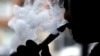 FILE - In this April 23, 2014, file photo, a man smokes an electronic cigarette in Chicago. 