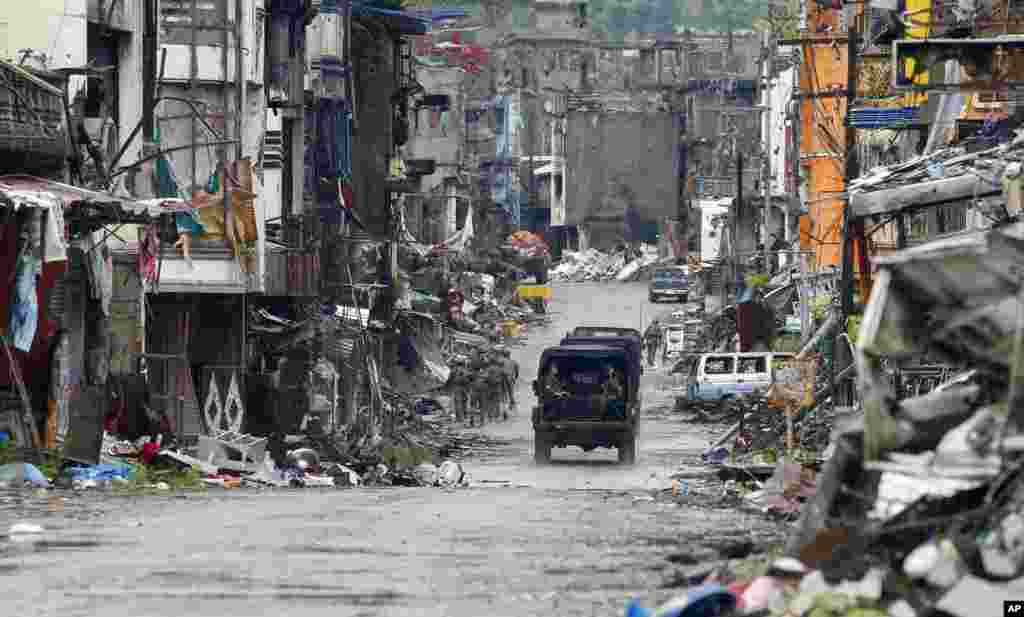 Amidst the ruins at "Ground Zero" Philippine troops return to their deployment after attending the ceremony where President Rodrigo Duterte declared the liberation of Marawi city in southern Philippines after almost five months of the siege by pro-Islamic State group militants.