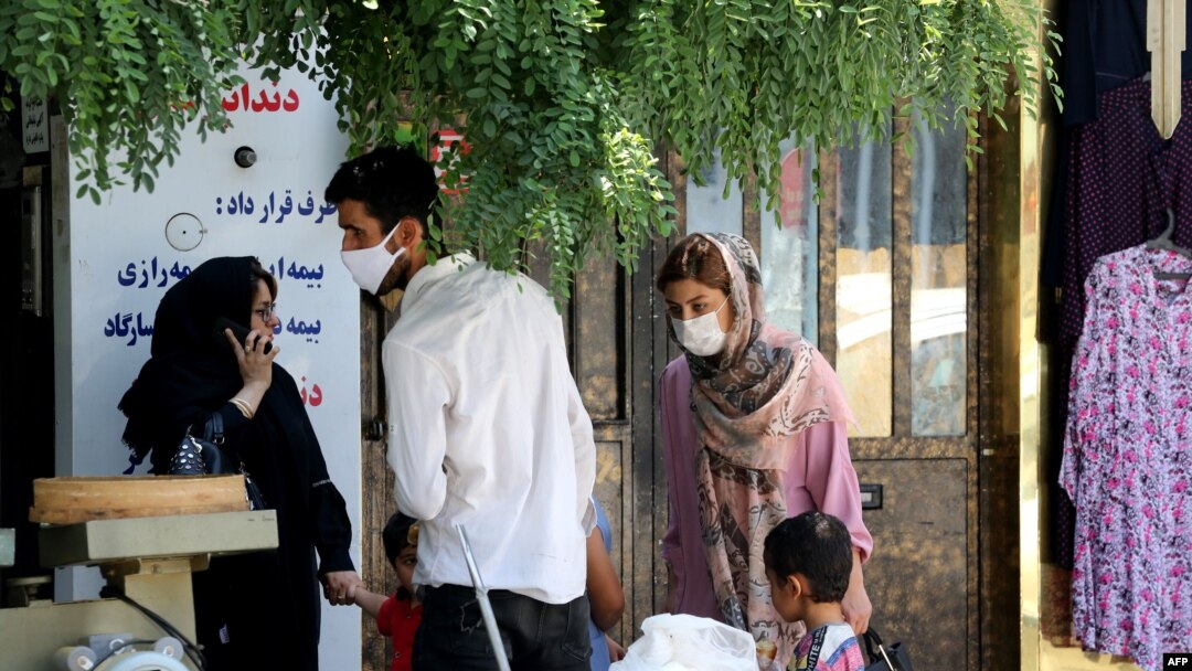 Mask-clad Iranians gather in a street in the capital Tehran, amid the ongoing novel coronavirus pandemic crisis, July 19, 2020.