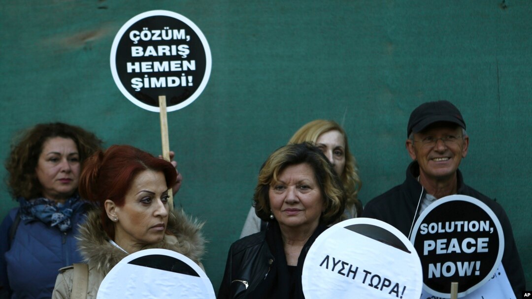 Greek and Turkish Cypriots holds banners reading in Greek, Turkish and English "Solution Now" in the divided capital Nicosia, Cyprus, April 2, 2017.