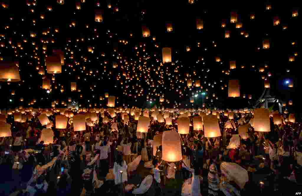 A crowd releases lanterns into the air as they celebrate the Yee Peng festival, also known as the festival of lights, in Chiang Mai, Thailand. The event is held to show respect to Buddha.