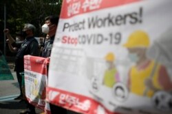 Members of the Korean Confederation of Trade Unions wearing face masks to help protect against the spread of the new coronavirus, shout slogans as they march during a May Day rally in Seoul, South Korea, May 1, 2020.