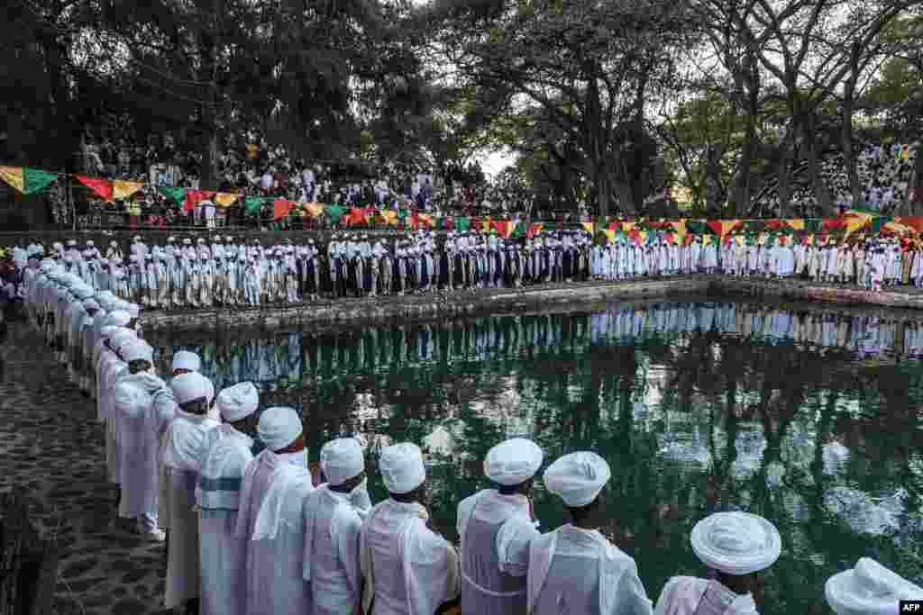 Ethiopian Orthodox Christian priests stand next to a pool during the celebration of Timkat, the Ethiopian Epiphany, in Fasilides Bath, in the city of Gondar.
