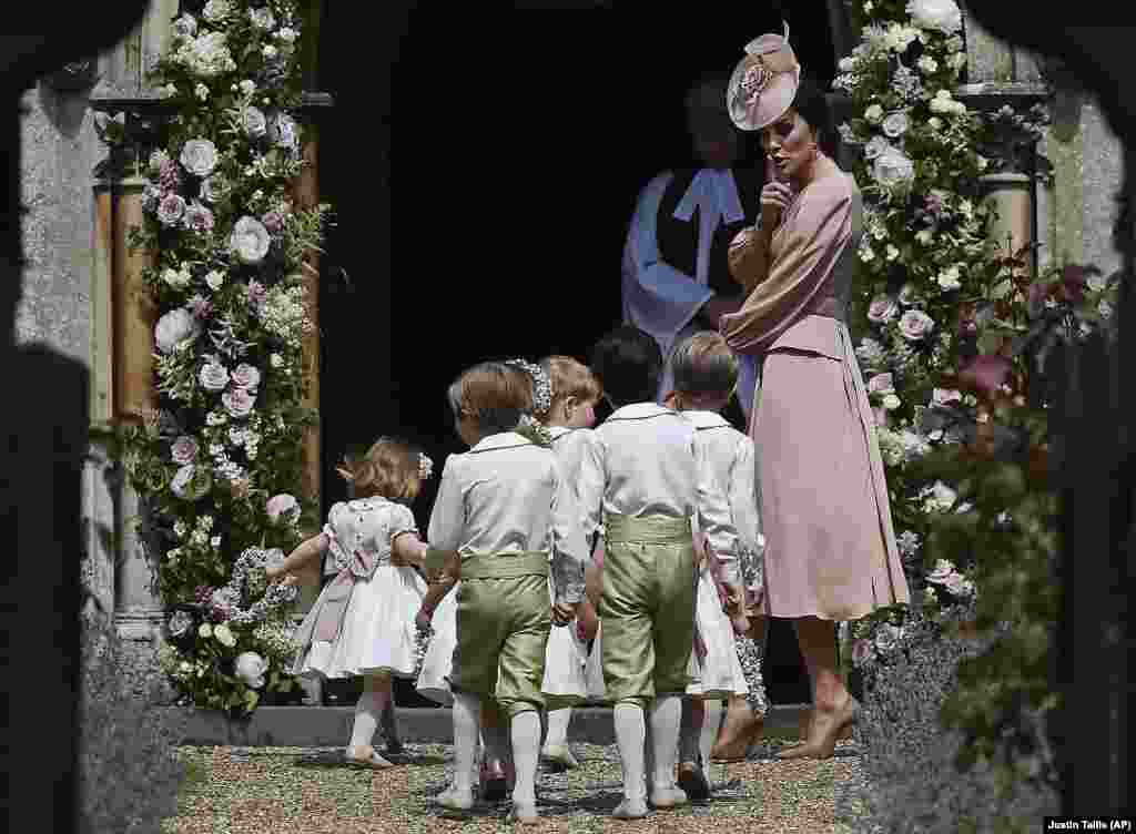Britain's Catherine, Duchess of Cambridge, right, gestures as she walks with the bridesmaids and pageboys as they arrive for her sister Pippa Middleton's wedding to James Matthews, at St. Mark’s Church in Englefield, England, May 20, 2017.