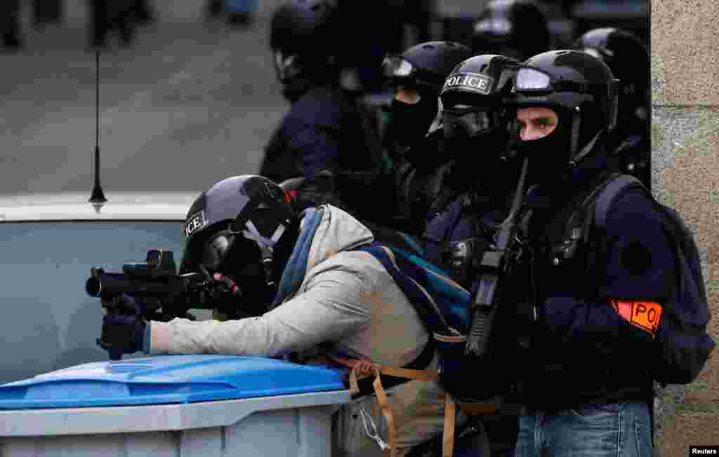 A French police officer aims at protesters with his LBD40 rubber bullets during a demonstration of the "yellow vests" movement in Nantes, Jan. 26, 2019.