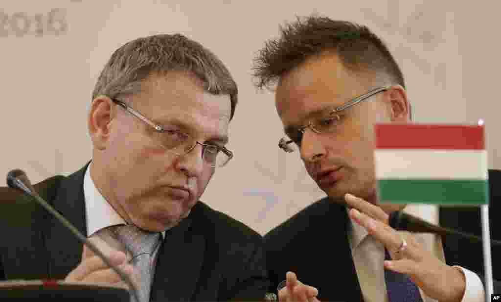 Czech Republic's FM Lubomir Zaoralek, left, talks to Hungarian FM Peter Szijjarto during a press conference as the Visegrad Group foreign ministers meet their counterparts from Germany and Luxembourg to talk about the current migration crisis in Prague, Czech Republic.