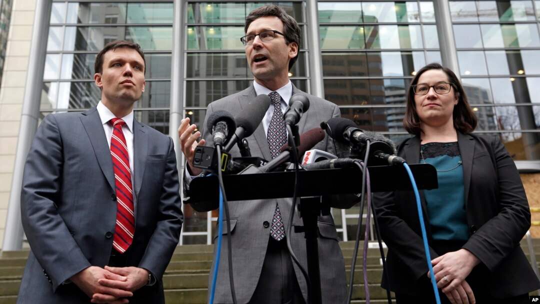 Attorney General Bob Ferguson, center, stands with Solicitor General Noah Purcell, left, and Civil Rights Unit Chief Colleen Melody as he speaks with media members on the steps of the federal courthouse after an immigration hearing there, March 15, 2017, 