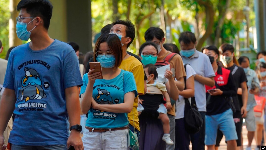 People queue up to vote in Hong Kong Sunday, July 12, 2020, in an unofficial primary for pro-democracy candidates ahead of legislative elections in September. Over 200,000 Hong Kongers voted in an unofficial Hong Kong primary that will help the pro…