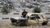 A Palestinian child stands inside a damaged car in front of a destroyed building in the war-devastated Bureij refugee camp in the central Gaza Strip on Feb. 7, 2025. 