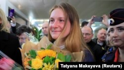 RUSSIA -- Convicted Russian agent Maria Butina, who was released from a Florida prison and then deported by U.S. immigration officials, holds flowers upon her arrival at Sheremetyevo International Airport outside Moscow, Russia October 26, 2019. 