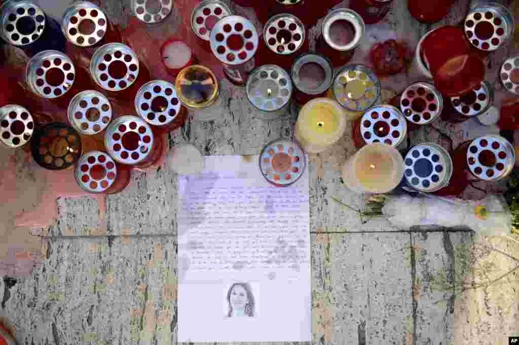 Candles, notes and paper cuttings lie next to the Love Monument in St. Julian, Malta, Oct. 17, 2017 the day after the killing of journalist Daphne Caruana Galizia. The Maltese investigative journalist who exposed the island nation's links to offshore tax havens through the leaked Panama Papers, was killed Monday when a bomb exploded in her car.