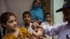 A Pakistani health worker gives a polio vaccine to a child in Rawalpindi, Pakistan, on May 6, 2014. 