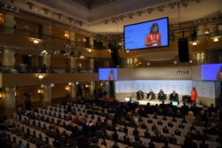 FILE - Participants are seen during a podium discussion at last year's Munich Security Conference, in Munich, southern Germany, Feb. 17, 2019.