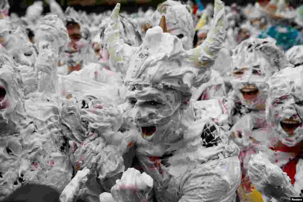Students from St. Andrews University are covered in foam as they take part in the traditional 'Raisin Weekend' in the Lower College Lawn, at St Andrews in Scotland, Britain.