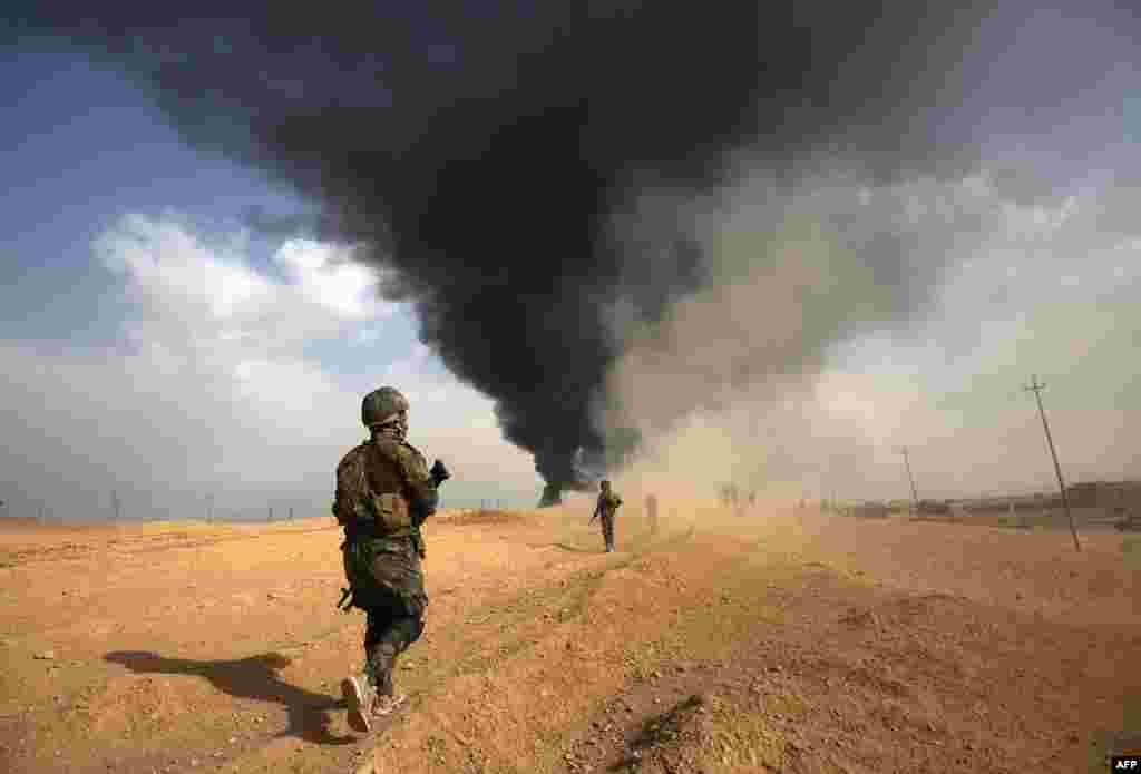 Iraqi forces and members of the Hashed al-Shaabi (Popular Mobilization units) advance towards the city of al-Qaim, in Iraq's western Anbar province near the Syrian border as they fight against remnant pockets of Islamic State group jihadists.