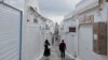 Tourists pass by closed shops in Fira town as Greek authorities are taking emergency measures in response to intense seismic activity on the popular Aegean Sea holiday island of Santorini, southern Greece, Feb. 3, 2025.