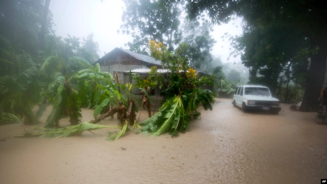 A vehicle sits next to a house, stranded in the flood waters caused by Hurricane Matthew, in Leogane, Haiti, Oct. 4, 2016. 