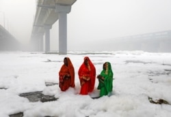 INDIA -- Hindu women worship the Sun god in the polluted waters of the river Yamuna during the Hindu religious festival of Chatth Puja in New Delhi, November 3, 2019