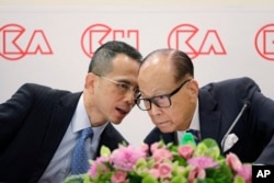 แฟ้มภาพ - หลี่ กา-ชิง ผู้ทรงอิทธิพลของฮ่องกง และประธานกลุ่มบ. CK Hutchison Holdings company (ขวา) คุยกับ วิกเตอร์ หลี่ ผู้เป็นบุตรชายและกรรมการผู้จัดการร่วม ที่งานแถลงข่าวผลประกอบการประจำปีที่ฮ่องกง เมื่อ 16 มี.ค. 2018