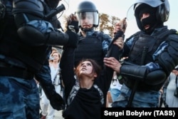 RUSSIA – MOSCOW, JULY 27, 2019: Police officers detain a woman during a protest on Trubnaya Square against against the banning of opposition candidates from Moscow municipal elections set for September 8.