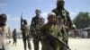 FILE - A young boy leads hard-line Islamist al-Shabab fighters as they conduct military exercises in northern Mogadishu's Suqaholaha neighborhood, Somalia.
