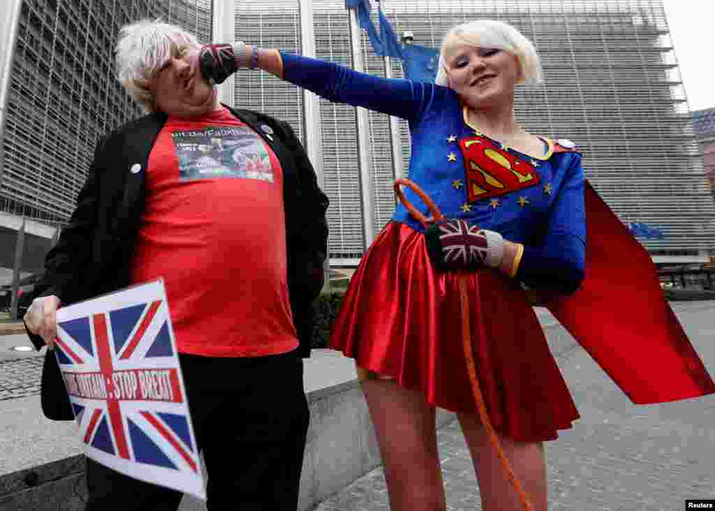 Britain's anti-Brexit activists Madeleina Kay, who nicknamed herself as "EU Supergirl," and Drew Galdron, who is also an impersonator of British Foreign Secretary Secretary Boris Johnson, perform outside the European Commission headquarters in Brussels, Belgium.