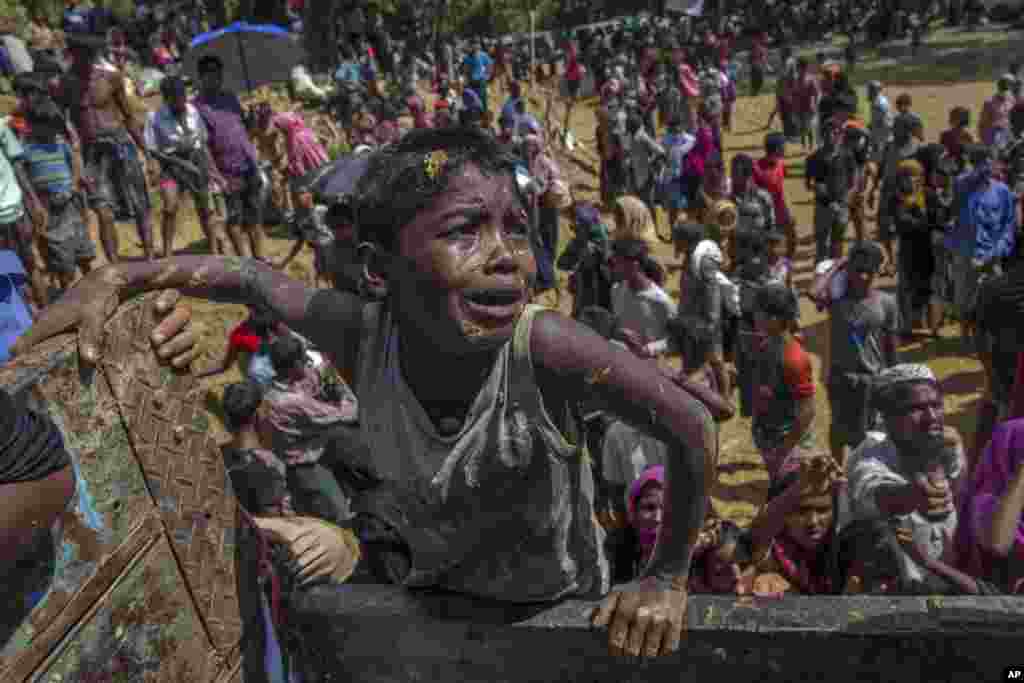 A Rohingya Muslim boy, who crossed over from Myanmar into Bangladesh, pleads with aid workers to give him a bag of rice near Balukhali refugee camp, Bangladesh.